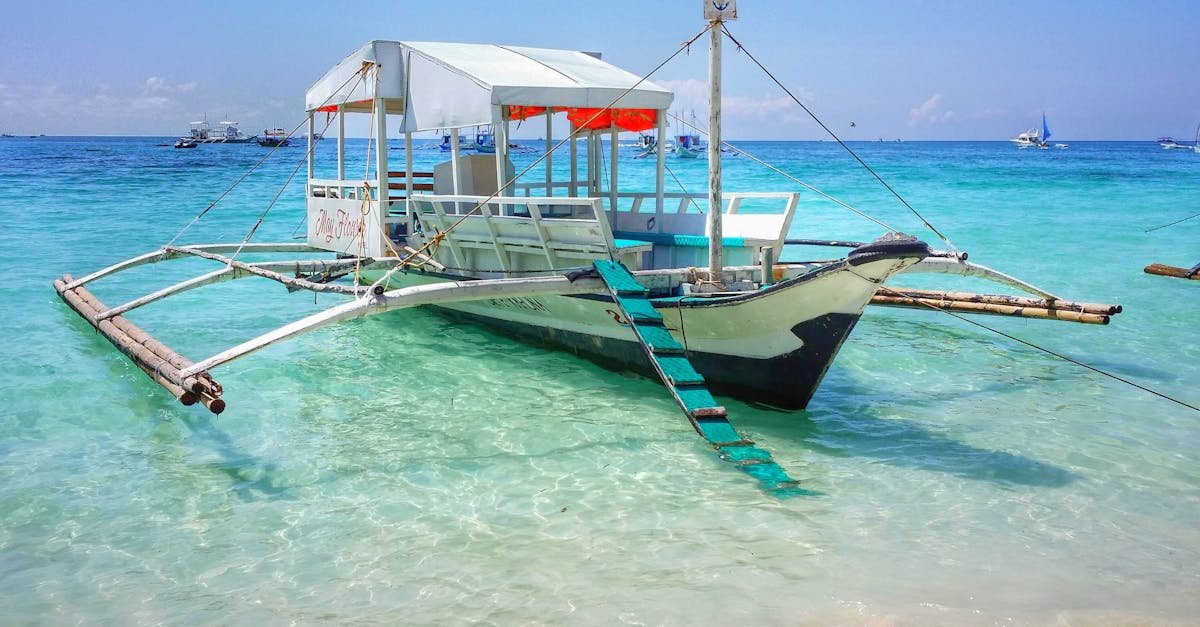 A traditional Filipino boat anchored on the turquoise waters of a stunning beach in the Philippines.