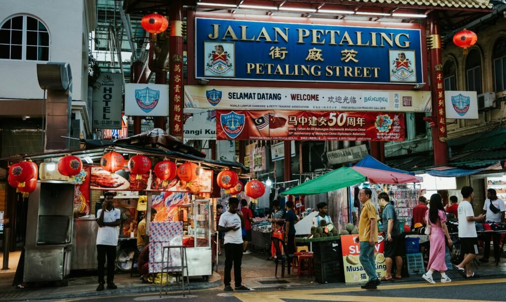 A bustling scene at Petaling Street in Kuala Lumpur featuring colorful stalls, vendors, and visitors.