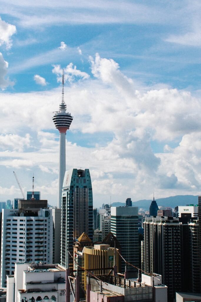 Aerial view of Kuala Lumpur's skyline with iconic KL Tower on a clear day.