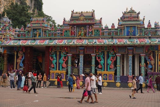 Colorful Sri Maha Mariamman Temple with diverse visitors in Malaysia.