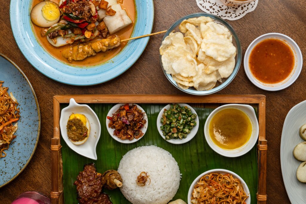 Delicious assortment of traditional Indonesian foods beautifully arranged for a feast.